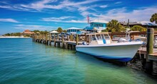 Anchored Boats At Bradenton Beach Pier On Anna Maria Island, Florida. Serene Daytime View Of Historic Pier And Crystal Blue Waters