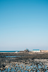 Canvas Print - Stone beach and house in Jeju Island, Korea