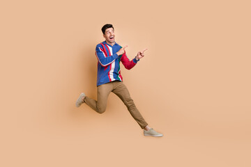 Poster - Full body photo of jumping crazy promoter directing fingers empty space mega sale proposition zara store isolated on beige color background