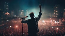 Unrecognizable Singer Male Standing On Stage In Concert With Crowd Of People, Live Music With Audience Hold Smartphone Taking Picture, Musician Man On Tour With Spot Light In City Night Background