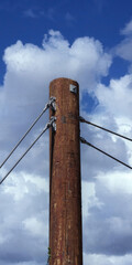 Wall Mural - Top of an electricity pylon under blue sky