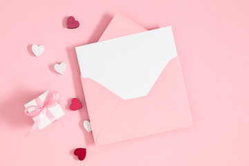 Wall Mural - Creative minimal Valentines day concept. Envelope, valentines, hearts confetti on pastel pink background. Flat lay, top view, copy space