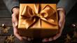 Man's hands delivering a Christmas gift. Young man giving a gold gift box. Top view closeup. Christmas and birthday concept. Holiday present. Gesture of love.