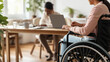 disabled man using laptop while sitting in wheelchair and working at home