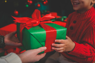 Gift box in the hands of mother and son, Christmas mood