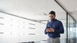 © insta_photos - Busy Indian business man project manager holding smartphone walking in office. Professional businessman entrepreneur going in hallway using mobile cell phone working on cellphone. Copy space.