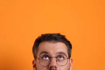 Canvas Print - Man in stylish glasses on orange background, closeup