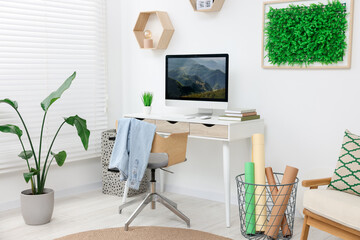 Canvas Print - Green artificial plant wall panel and desk with computer in light room. Interior design