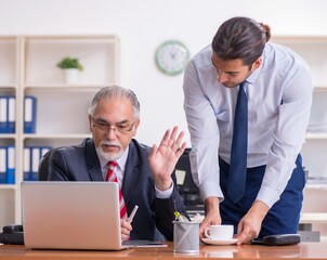 Wall Mural - Old boss and young male employee in the office