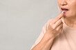 © Pixel-Shot - Beautiful mature woman taking pill on grey background