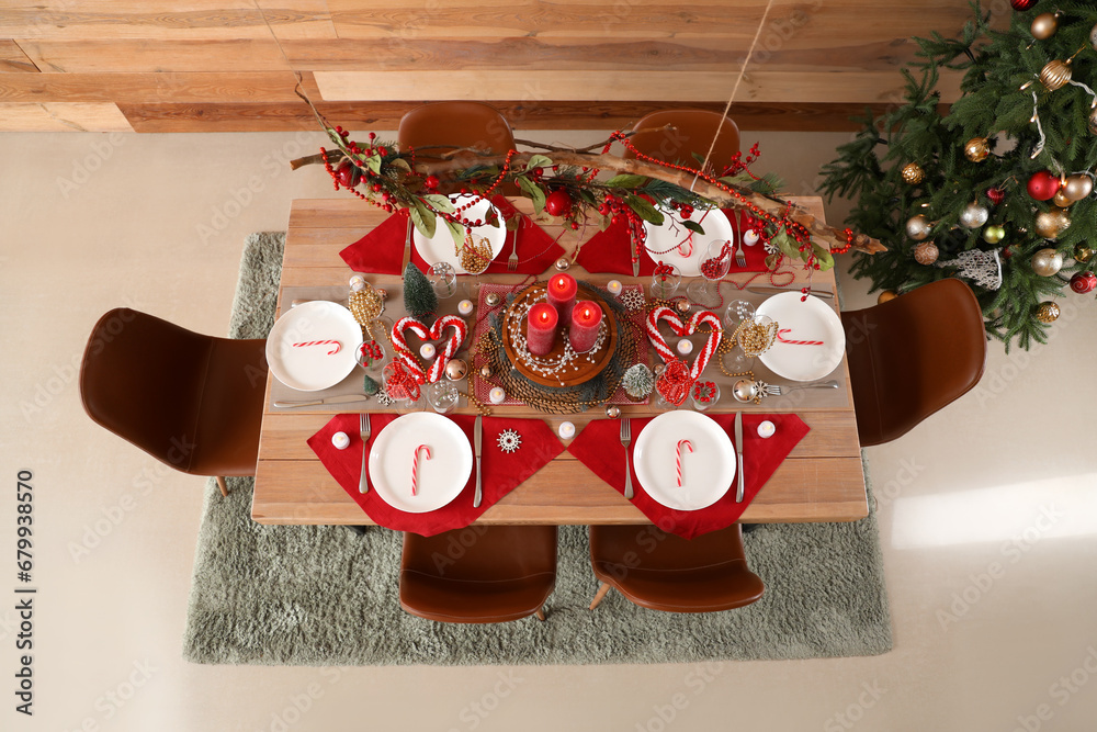 Festive dining table with Christmas setting and beads in room, top view