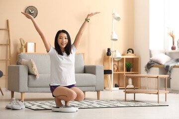 Wall Mural - Beautiful young Asian woman with scales at home. Weight loss concept