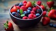 A bowl of colorful mixed berries, including strawberries, blueberries, and raspberries