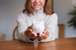© Farknot Architect - Closeup image of a woman holding a piggy bank for saving money and financial concept
