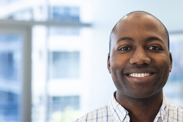 Wall Mural - Portrait of happy african american man in hospital waiting room with copy space