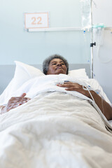 Wall Mural - African american senior female patient lying in bed in sunny hospital room