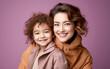 © hakule - Fashion smiling mother holding her kid on solid color background, love concept