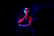 © Kaushik - A women with Halloween Makeup in blue red light giving out a horror look wearing black gown in black background