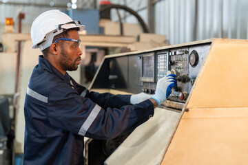 Wall Mural - Black male engineer working and operating cnc machine in control panel at factory workshop heavy metal industrial