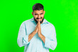 Sneaky cunning Indian young man with tricky face gesticulating and scheming evil plan, thinking over devious villain idea, cheats, jokes, pranks. Arabian guy isolated on green chroma key background