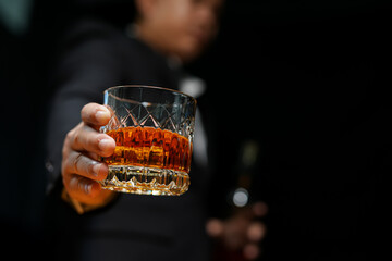 Wall Mural - Closeup businessmen holding a glass of whiskey