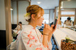 Portrait of a young woman wearing Japanese yukata summer kimono and putting on makeup in a tea shop. Kyoto, Japan.