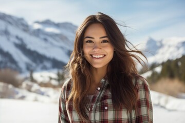 Sticker - Portrait of a cheerful woman in her 20s dressed in a relaxed flannel shirt against a snowy mountain range. AI Generation