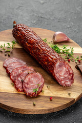 Wall Mural - Pieces of salami sausage on a cutting board, vertical image. top view. copy space for text