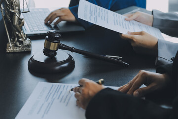 Business and lawyers discussing contract papers with brass scale on desk in office. Law, legal services, advice, justice and law concept picture with film grain effect