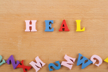 HEALword on wooden background composed from colorful abc alphabet block wooden letters, copy space for ad text. Learning english concept.