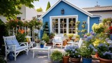 Fototapeta Uliczki - Lovely blue house with beautiful garden and farmhouse vibes Terrace with wicker baskets greenery and white furniture Backyard with gardening tools