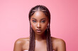 © Surachetsh - The portrait of an attractive young black female model in pink outfit  with braids hairstyle and full makeup isolated on a pink background, shot in a studio. Generative AI.