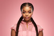 © Surachetsh - The portrait of an attractive young black female model in pink outfit  with braids hairstyle and full makeup isolated on a pink background, shot in a studio. Generative AI.