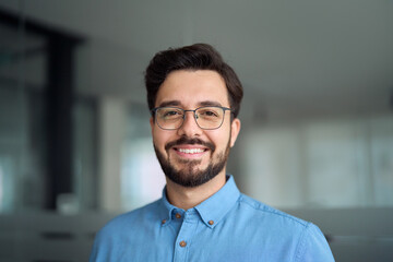 Smiling happy young latin business man bank manager, adult professional businessman executive in office, male entrepreneur, software developer or company employee wearing glasses, headshot portrait.