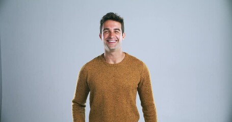 Poster - Young happy man, pointing and calling you in confidence isolated against a gray studio background. Portrait of handsome or attractive male person or model with finger or wink for choice on mockup
