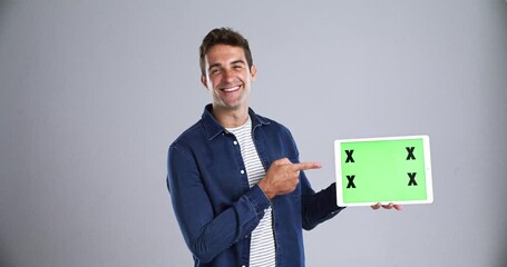 Poster - Happy man pointing at tablet, green screen and mockup space, advertising and marketing. Portrait, technology and chroma key gesture for information, tracking markers and show app on grey background