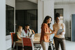© BGStock72 - Two young business women with digital tablet in the office in front of their team
