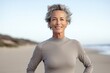 © CogniLens - Portrait of a merry woman in her 50s sporting a long-sleeved thermal undershirt against a sandy beach background. AI Generation