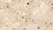 Seamless beige granite texture with quartz and feldspar spots