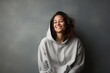 © CogniLens - Portrait of a glad woman in her 30s sporting a comfortable hoodie against a minimalist or empty room background. AI Generation