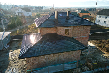 Wall Mural - Aerial view of house roof top covered with ceramic shingles. Tiled covering of building under construction
