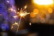 © st.kolesnikov - sparklers close-up on a blurred background of garlands