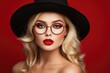 Lovely Lady: Blonde Woman With Hat and Glasses Makes Kissy Face on Red Background