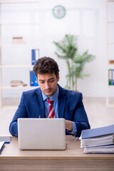 Wall Mural - Young male employee working in the office