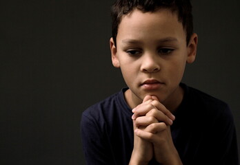 Poster - boy praying to God with hands held together with people sock image stock photo	