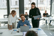 © Kostiantyn - Group of young business people discussing something and smiling while sitting at the office table
