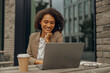 © Yaroslav Astakhov - Pretty businesswoman working on laptop while sitting in cafe terrace