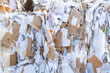 A tightly compressed briquette of paper, cardboard and plastic film before being sorted in a recycling plant. Recycled materials. Close-up, full frame