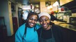 © Adriana - Smiling young black female restaurant kitchen workers looking at the camera