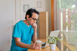 © kongga studio - Smiling nurse using digital tablet in employee lounge. Male nurse takes a break outside of a coffee shop.